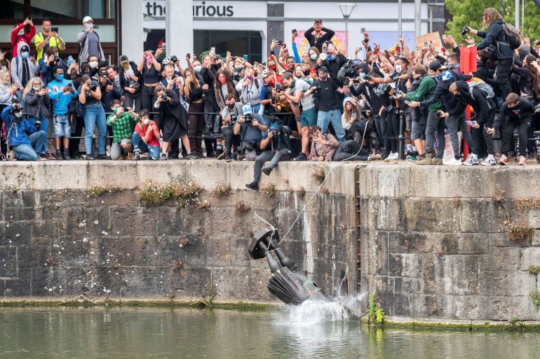 The statue of Edward Colston falls into the water after protesters pulled it down in Bristol