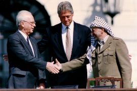 PLO Chairman Arafat shakes hands with Israeli PM Rabin after the signing of the Israeli-PLO peace accord, in Washington