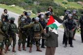 2月25日，一名巴勒斯坦男子站在以色列军队面前，抗议以色列在以色列占领的西岸建立定居点 (路透)