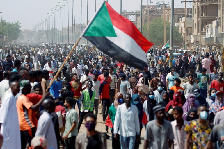 Civilians gather as members of Sudanese pro-democracy protest on the anniversary of a major anti-military protest, as groups loyal to toppled leader Omar al-Bashir plan rival demonstrations in Khartoum