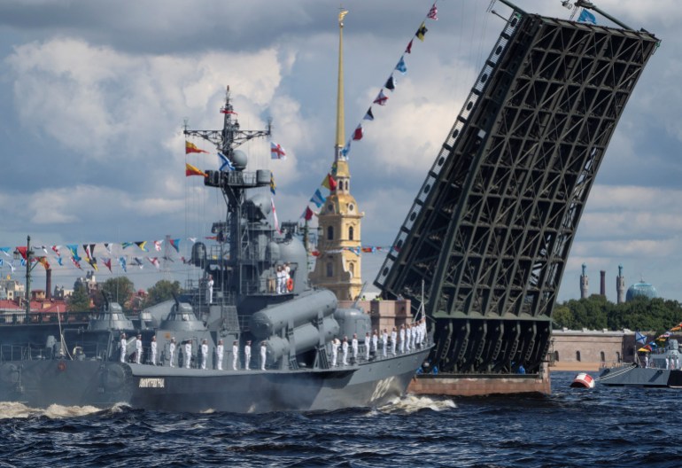 A Russian warship sails past the Dvortsoviy Bridge over the Neva River during the Navy Day parade in Saint Petersburg