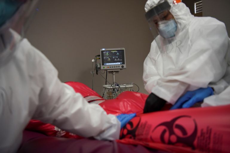 The body of a patient, who died during an intubation procedure, is prepared by nurses to be transported to a morgue in Houston