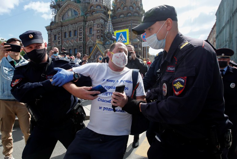 Policemen detain a man during an anti-Kremlin rally in Saint Petersburg