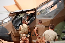 French soldiers work on a Tiger attack helicopter at the Operational Desert Plateform Camp (PfOD) during the Operation Barkhane in Gao