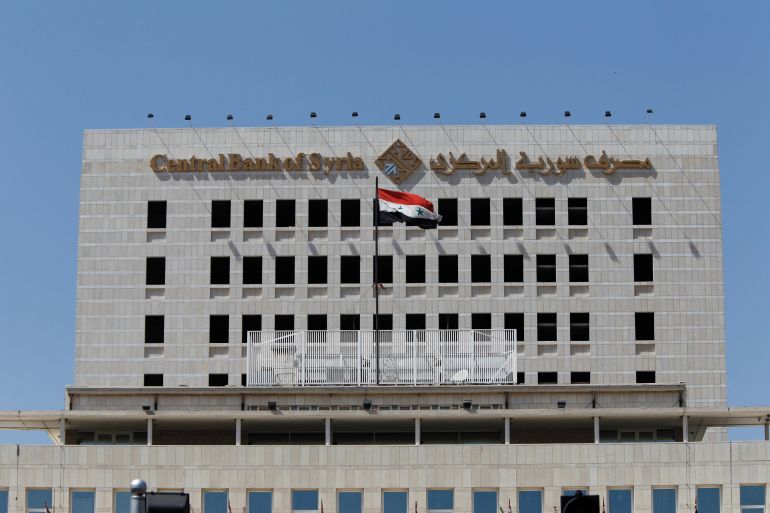 A Syrian national flag flutters on the Central Bank of Syria building in Damascus,