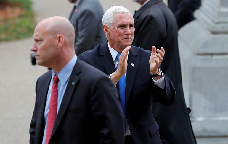 U.S. Vice President Pence reacts to supporters outside the New Hampshire State House as he walks near his Chief of Staff Marc Short in Concord