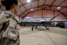 A French soldier of the regional anti-insurgent Operation Barkhane stands in front of a General Atomics MQ-9 Reaper drone version Block 1 in Niamey