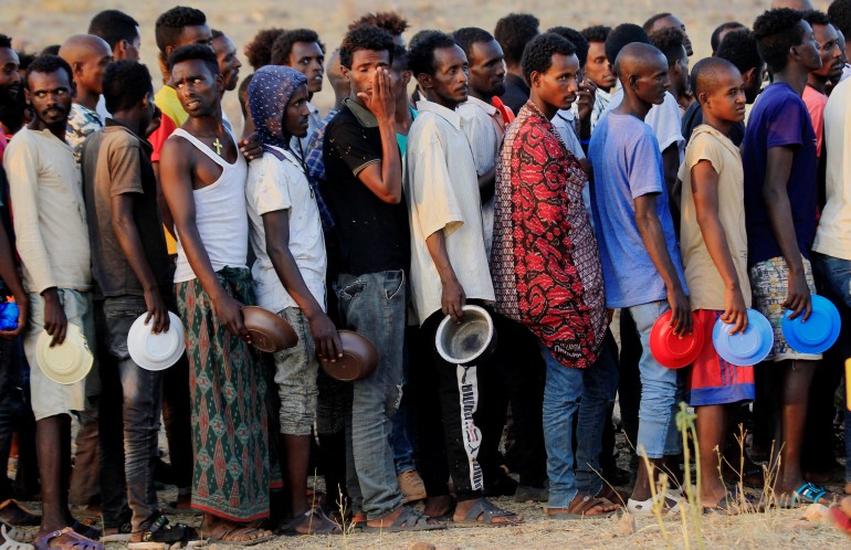 Ethiopian men who fled war in Tigray region, queue for wet food ration at the Um-Rakoba camp, on the Sudan-Ethiopia border in Al-Qadarif state