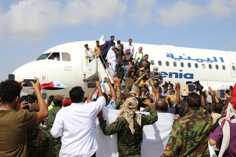 People wait to greet members a newly formed cabinet for government-held parts of Yemen upon their arrival at Aden airport, before an attack on the airport, in Aden