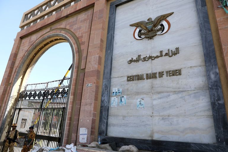 Guards stand at the gate of the Central Bank of Yemen in Sanaa