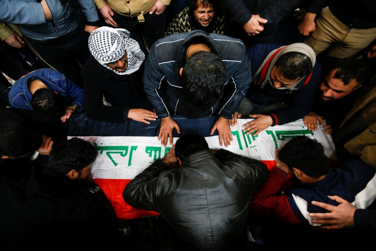 Mourners gather near the coffin of a man, who was killed in a twin suicide bombing attack in a central Baghdad market, during a funeral in Najaf