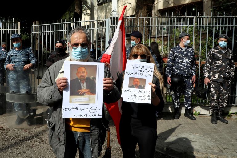People hold a picture of Lokman Slim, a prominent Lebanese Shi'ite critic of Iran-backed Hezbollah who was found killed, outside the Justice Palace in Beirut