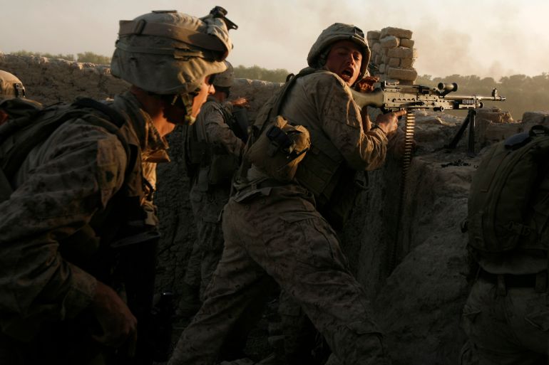 U.S. marines fire during a Taliban ambush as they carry out an operation to clear an area in Helmand province