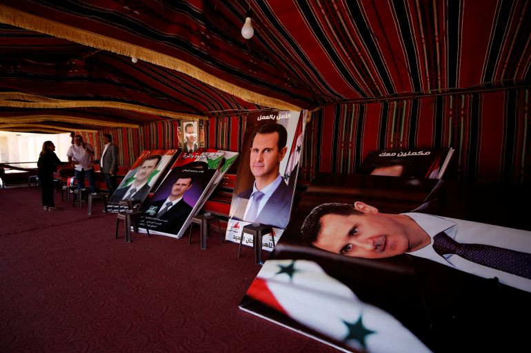 Posters depciting Syria's President Bashar al-Assad are pictured inside a campaign tent, in the district of al-Waer