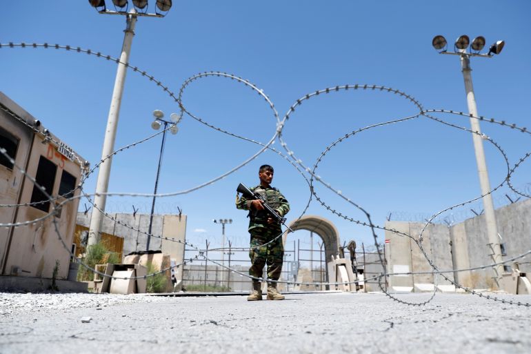 Afghan National Army soldier stands guard at Bagram U.S. air base gate on day of troop departure
