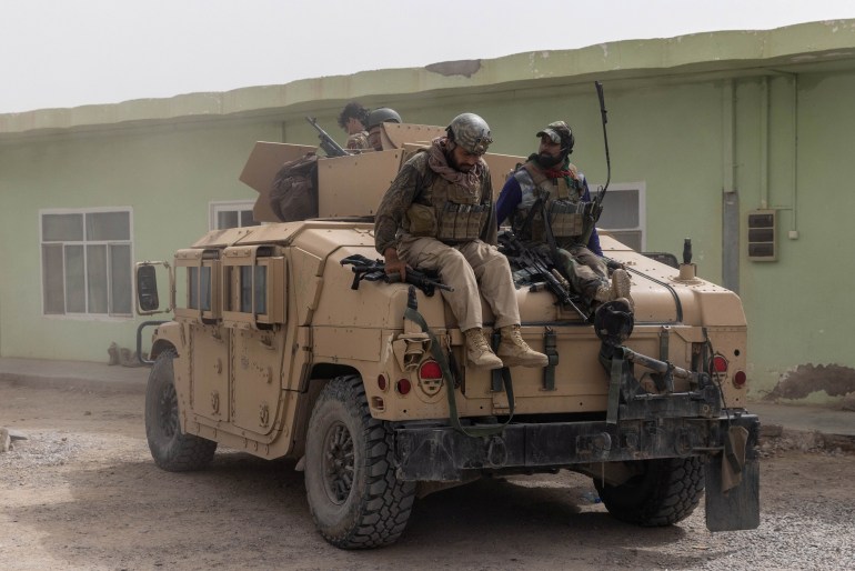 Members of Afghan Special Forces climb down from a humvee as they arrive at their base after heavy clashes with Taliban during the rescue mission of a police officer besieged at a check post, in Kandahar province