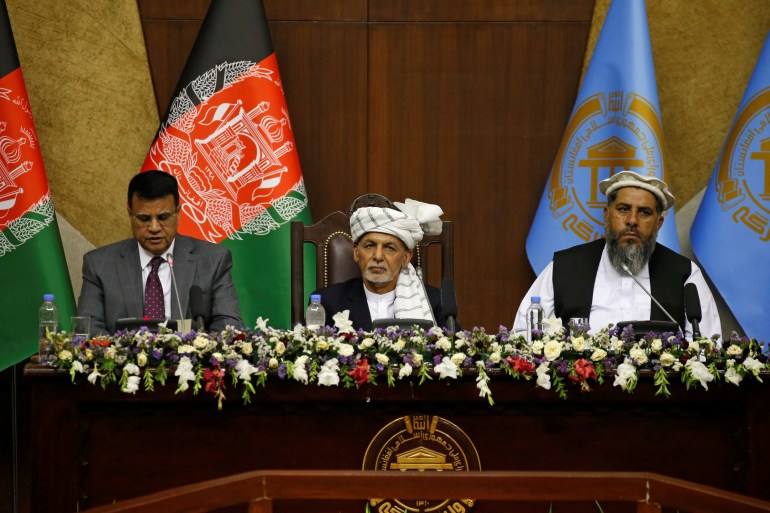 Afghan President Ashraf Ghani (C) looks on as he sits at the parliament in Kabul