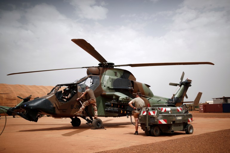 French soldiers work on a Tiger attack helicopter at the Operational Desert Plateform Camp (PfOD) during the Operation Barkhane in Gao