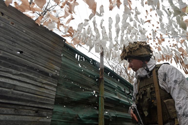 Ukrainian service members guard the area near the line of separation in the Donetsk Region