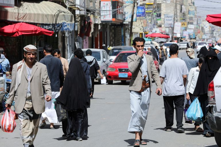 People walk on a street hours before a two-month nationwide truce takes effect, in Sanaa