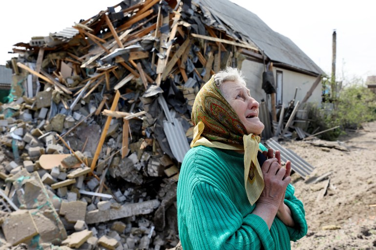 Valentyna reacts in front of a destroyed house amid Russia's invasion of Ukraine, in Lyman