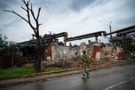 2022年5月18日，乌克兰东部“顿涅茨克人民共和国”的辖区内，一名俄罗斯士兵正在巡视马里乌波尔被摧毁的伊里奇冶金厂 (美联社)