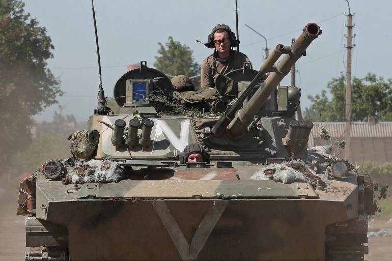 Service members of pro-Russian troops ride an infantry fighting vehicle in Popasna