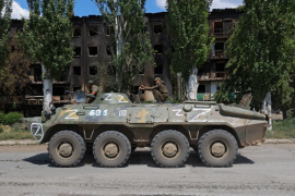 亲俄部队的军人在卢甘斯克地区驾驶装甲运兵车 (路透)