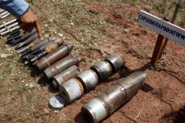 2011年7月7日周四，柬埔寨金边以北约245公里（152英里）处的柏威夏省，一位柬埔寨排雷专家指着在销毁仪式前展示的未爆炸炸弹 (美联社)