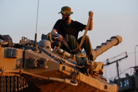 2023 年 11 月 30 日，在以色列南部加沙附近，哈马斯与以色列暂时休战期间，一名以色列士兵正在给梅卡瓦坦克的机枪重新装弹（路透）