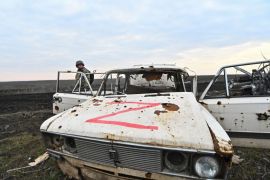 乌克兰武装部队第65机械化旅的一名乌克兰军人在前线村庄罗博季涅附近检查一辆受损的俄罗斯汽车 (路透)