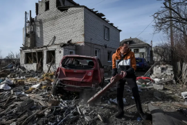 乌克兰第聂伯罗，一名当地居民在俄罗斯无人机袭击中受损的住宅楼附近准备拖走一辆受损汽车（路透）