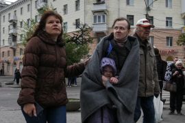 乌克兰第聂伯罗的居民站在遭到俄罗斯导弹袭击的公寓大楼前 (路透社)
