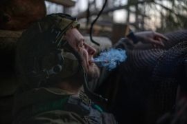 2024 年 4 月 12 日，在顿涅茨克克里明纳方向前线距离俄罗斯军队约1公里的防空洞内，亚速旅的一名乌克兰军人正在抽烟以等待开火命令 (美联社)